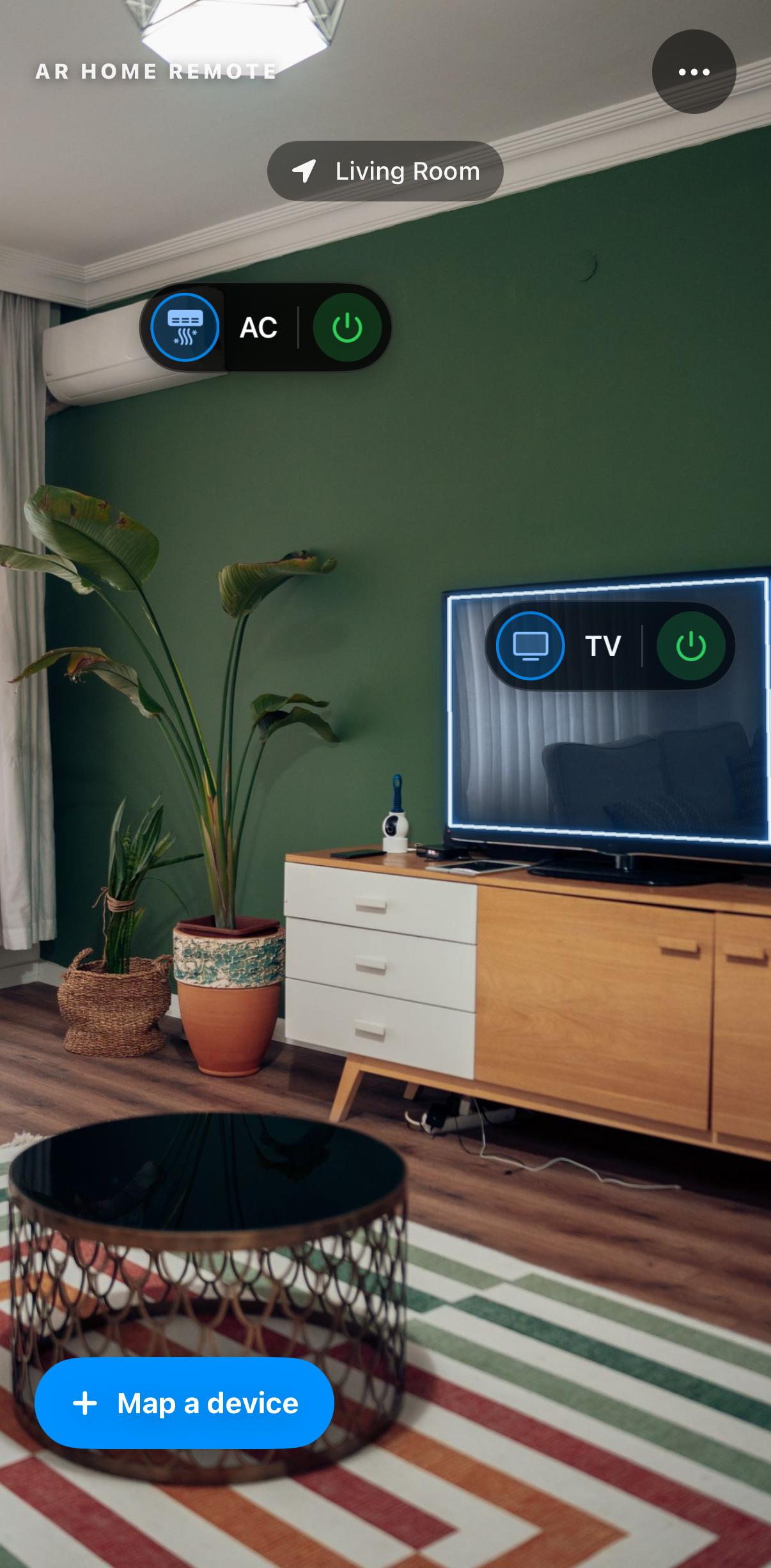 The ready state: the living room through the camera, a pill on the AC, a pill on the TV wearing the edge glow, a Living Room chip at the top and a Map a device button at the bottom.